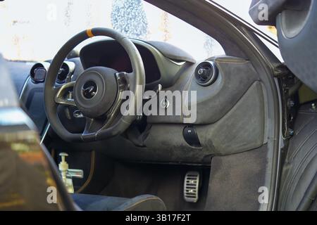 Innenansicht eines McLaren Sportwagens mit Details aus Lenkrad, Armaturenbrett und Kohlefaser. Stockfoto