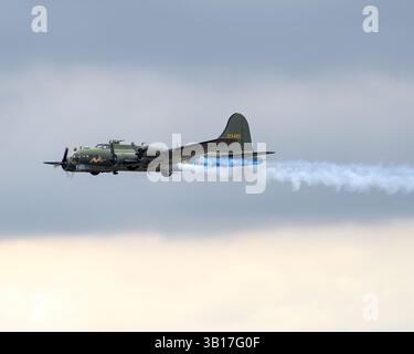 Eine Vintage Boeing B-17 Flying Fortress, „DF“, schwebt durch einen hellen Himmel und zeigt ihr historisches Militärdesign in Duxford, England. Stockfoto