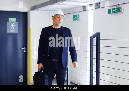 Architekt in eleganter Freizeitkleidung, der während eines strukturellen Rundgangs zeigt. Kommunikation am Arbeitsplatz. Stockfoto