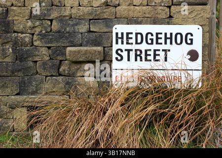 Der Igel Highway am RHS Harlow Carr Gardens in Harrogate, Yorkshire, Großbritannien, öffnet sich am Fuße einer Steinmauer, um kleine Tiere zu passieren. Stockfoto