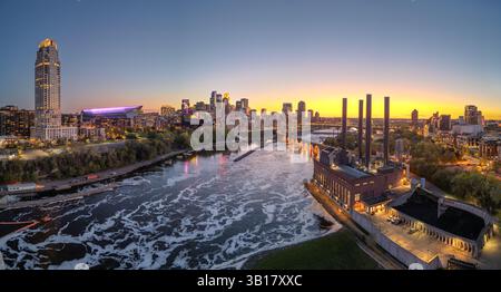 Die Skyline der Innenstadt von Minneapolis, Minnesota, USA über dem Mississippi in der Abenddämmerung. Stockfoto