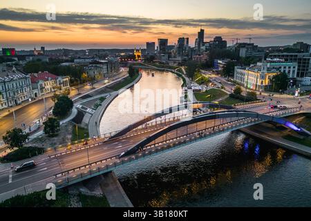 Die Mindaugas-Brücke überquert den Neris River und Vilnius Stadtlandschaft am Horizont am Abend Stockfoto