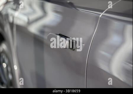 Moderner Türgriff, neues Auto. Intelligente einziehbare Türgriffe. Außendetails des Fahrzeugs. Schließen Sie den Türgriff des Fahrzeugs. Fahrzeugausrüstungskonzept. Stockfoto