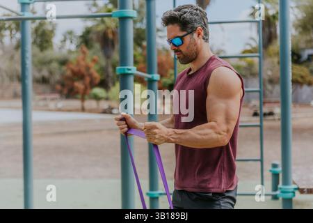 Ein muskulöser starker Mann trainiert in einem Outdoor-Fitnessstudio, aktives Lifestyle-Konzept. Stockfoto