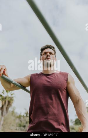 Foto von unten von einem fitten Mann, der in einem Fitnessstudio im Freien trainiert, motiviert und fokussiert. Stockfoto