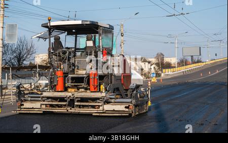 Moderne Asphaltfertigungsmaschine, die auf der Straße der Stadt arbeitet Stockfoto