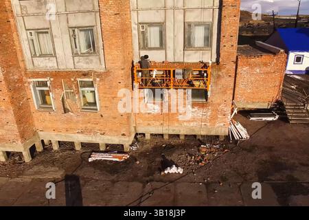 Verstärkung von tragenden Wänden eines Plattenhauses, Verkleidung von Plattenwänden mit Ziegeln. Stockfoto