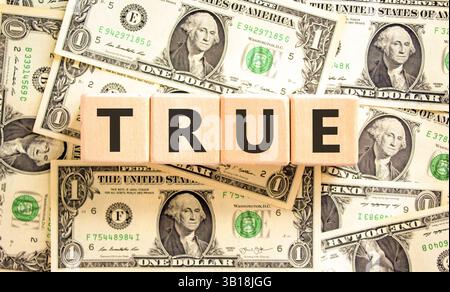 True-Symbol. Das Konzept gilt für wunderschöne Holzblöcke. Dollarscheine. Wunderschöner Hintergrund von Dollarscheine. Business, Lifestyle, Support und True Stockfoto