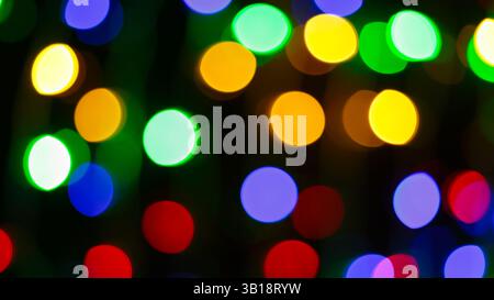 Bunte abstrakte Bokeh-Lichter mit gelben grünen blauen roten orangefarbenen Kreisen auf dunklem festlichem Hintergrund Stockfoto