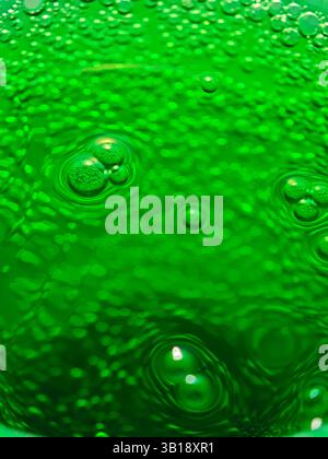 Erfrischendes grünes Soda mit Blasen, die konzentrische Kreise bilden, ideal für Hintergründe und Projekte im Zusammenhang mit alkoholfreien Getränken Stockfoto