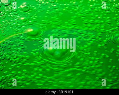 Erfrischendes grünes, sprudelndes Wasser mit Blasen, die konzentrische Kreise bilden, für ein faszinierendes Bild Stockfoto