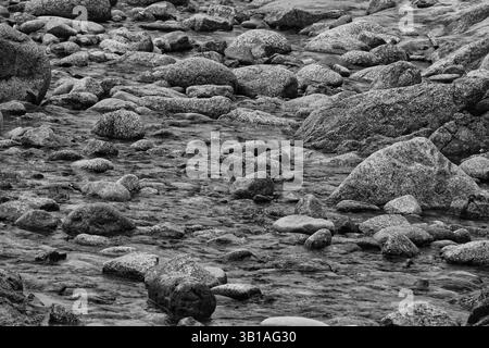 Garrapata State Park and Beach, Monterey County, Kalifornien - 23. April 2025 Wasser fließt über Felsen und Kieselsteine in den Ozean Stockfoto