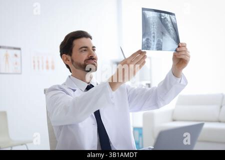 Lächelnder Arzt untersucht Hals-MRT in der Klinik Stockfoto