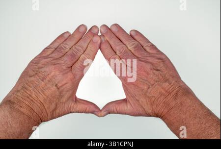 Kaukasische männliche Hände bilden ein Dreieck auf weißem Hintergrund Stockfoto