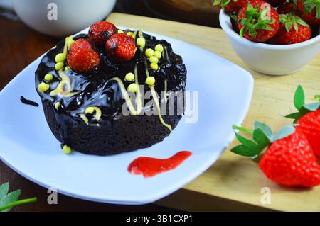 Schokoladenkuchen mit Erdbeerbelag. Draufsicht. Schokoladenkuchen mit frischen Erdbeeren bestreut. Hausgemachte dunkle Schokoladen-Brownies und Erdbeeren Stockfoto