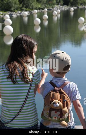August 2010 - Calgary, ab, Kanada - CALGARY, ab.: 15. AUGUST 2010 – Jane Kerr, 11 (links) und ihr Bruder Andrew, 3, betrachten die Kunstwerke des berühmten Künstlers Laurent Louyer und seines Londoner Studios Creatmosphere am Bow River in der Nähe des Prince's Island Park in Calgary, Alberta am 15. August 2010. Bei Nacht leuchten alle Sphären im Rahmen der Feier des Bow River 2010 (Leah Hennel, Calgary Herald) (Bild: © Leah Hennel/Postmedia News/ZUMApress.com) Stockfoto
