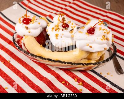 Eine Vollformataufnahme eines Banana Split Eiss, das auf einem Tisch sitzt. Stockfoto