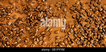 Ein lebendiges und fesselndes Angebot an frisch gerösteten Kaffeebohnen mit reichhaltiger Textur und lebendigen Farben. Kaffeebohnen auf einem goldenen Gelb Stockfoto