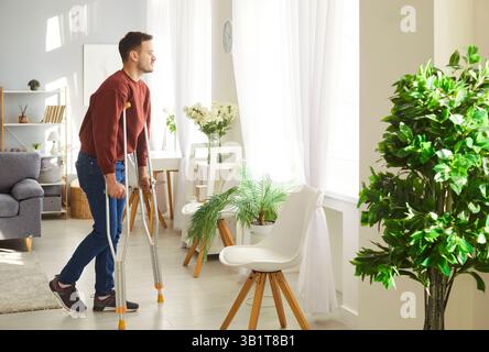 Innenaufnahme eines Mannes, der auf Krücken posiert, wird nach Beinverletzungen oder Traumata rehabilitiert Stockfoto