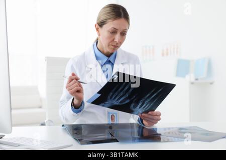 Arzt untersucht MRT-Scan am Schreibtisch im Krankenhaus Stockfoto