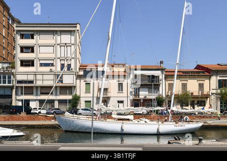 Ein Segelboot im Burlamacca-Kanal im Hafen von Viareggio, wo es in das Tyrrhenische Meer mündet, im Sommer Viareggio (Lucca), Toskana, Italien Stockfoto