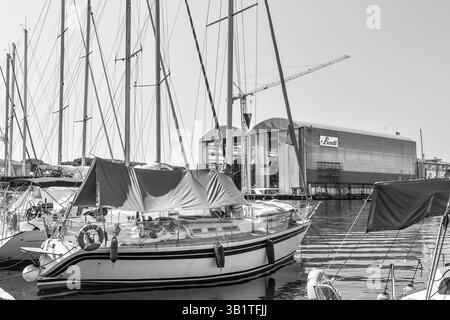 Schwarz-weiß. Boote, die im Dock Darsena Italia vor Anker gebracht werden, mit der Werft Azimut Benetti im Hintergrund, Viareggio (Lucca), Toskana, Italien Stockfoto