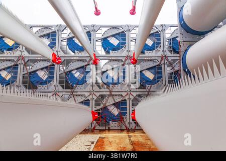 Die Rotorblätter von Windturbinen wurden in speziellen Befestigungselementen auf dem Deck des Schiffes für den Transport auf dem Schiff angekettet. Stockfoto