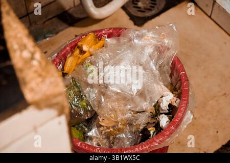 Eine Nahaufnahme eines mit Kunststoff- und organischen Abfällen gefüllten Abfallbehälters Stockfoto