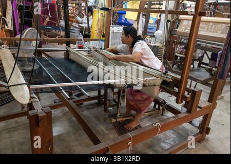 Ein Seidenraupenmaschinist, der einen Weber im „Thai Silk Village“ in Ban Sanuan NOK, einem Dorf in der Nachbarschaft von Chiang Mai, dem thailändischen seco, betreibt Stockfoto