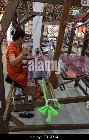 Ein Seidenraupenmaschinist, der einen Weber im „Thai Silk Village“ in Ban Sanuan NOK, einem Dorf in der Nachbarschaft von Chiang Mai, dem thailändischen seco, betreibt Stockfoto