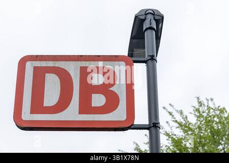 DB-Schild am Bahnhof bei bewölktem Himmel 25.04.25, Selters: Symbolfoto, Illustrationsbild, Symbolbild, Illustrationsfoto, Alltagsszene Nahaufnahme eines DB-Schildes Deutsche Bahn an einem Bahnhof in Deutschland. Das leicht verwitterte rote Logo auf weißem Grund ist an einem Laternenmast befestigt. Der Himmel ist bewölkt, im Hintergrund sind leicht unscharf grüne Baumkronen zu erkennen. Typisches Motiv des deutschen Bahnverkehrs. . Selters Hessen Deutschland *** DB-Schild am Bahnhof bei bewölktem Himmel 25 04 25, Selters Symbol Foto, Illustrationsbild, Symbolbild, Illustrationsfoto, jeden Tag Stockfoto