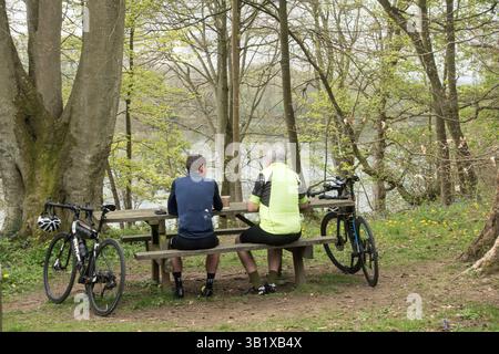 Zwei Radfahrer ruhen am Bolam Lake in Northumberland, England, Großbritannien Stockfoto