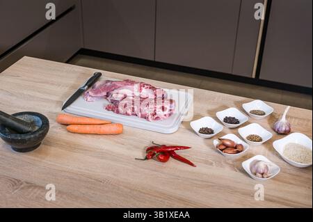 Ein Stück Rindfleisch an Bord, während Sie Pilaw mit Gewürzen und Reis zubereiten. Innenausstattung der Küche. Pilaw Rezept auf Bildern. Kochschritt. Stockfoto
