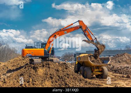 Komatsu HM300 Kipplaster und Hitachi 210LC Hydraulikbagger für die Baustellenvorbereitung. Ontario County. Farmington, New York Stockfoto