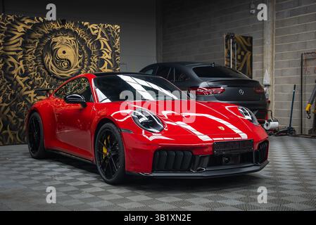 Rot 2025 Porsche 911 GT3 922 mit weißen Streifen in moderner Garage Stockfoto