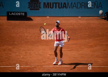 Madrid, Spanien. April 2025. Der Serbier Novak Djokovic spielt gegen den Italiener Matteo Arnaldi (nicht sichtbar) während des zweiten Rundenspiels der Mutua Madrid Open 2025 in La Caja M·gica. Endpunktzahl: 6:3, 6-4 für Matteo Arnaldi. Quelle: SOPA Images Limited/Alamy Live News Stockfoto