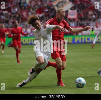 München, Deutschland. April 2025. Konrad Laimer (R) von Bayern München streitet mit Kaishu Sano vom FSV Mainz 05 während des Fußball-Spiels der ersten Bundesliga zwischen Bayern München und FSV Mainz 05 am 26. April 2025 in München. Quelle: Philippe Ruiz/Xinhua/Alamy Live News Stockfoto