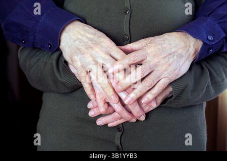 Ineinander verflochtene Hände eines älteren Ehepaares, das Zuneigung, Intimität und eine lebenslange Bindung zeigt. Das Bild weckt Gefühle von Fürsorge, Wärme und dauerhaftem miteinander Stockfoto