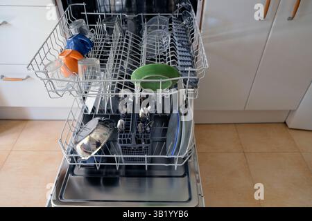 Voll beladener Geschirrspüler mit gereinigtem Geschirr, Utensilien und Gläsern in einer modernen Küchenumgebung, bereit zum Entladen. Ideal für Illustrationen Stockfoto