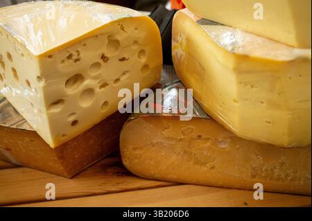 Grosse Kreise Frischkäse in Sektion. Verschiedene Käsesorten werden an einem Marktstand ausgestellt Stockfoto