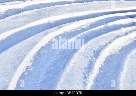 Traktor mehrere parallele Spuren in schneeblauem Ton sonnigem Hintergrund Stockfoto