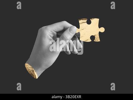 Hand hält ein goldenes Puzzleteil. Menschlicher Finger mit strukturiertem Folienelement, schwarzer Hintergrund. Konzept der Verbindung, des Beitrags, der Finanzierung, Stockfoto