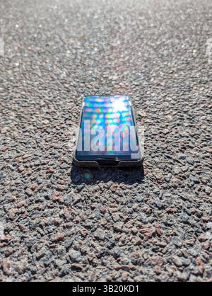 Das Smartphone liegt auf dem Asphalt Stockfoto