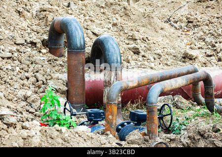 Neue geschweißte Stahlrohrleitung mit Ventilen im Boden. Stockfoto