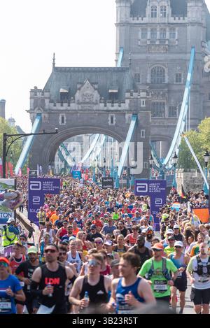 Tower Hill, London, Großbritannien. April 2025. Rund 56.000 Menschen nehmen am TCS London Marathon 2025 Teil, darunter die weltbesten Elite-Läufer und Rollstuhlsportler. Die Massen von Club- und Fun-Läufern folgen ihnen, wobei viele große Summen für wohltätige Zwecke sammeln. Massen überqueren die Tower Bridge Stockfoto