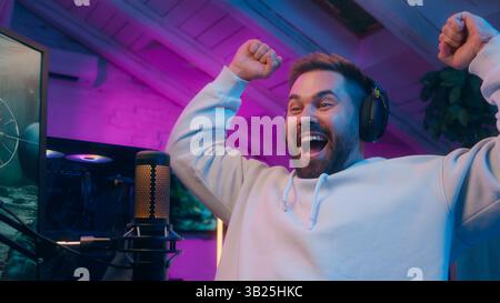 Fröhlicher kaukasischer männlicher Gamer-Streamer spielt Computer-Tech E-Sport zu Hause Mann Sieger Shout Sieger Rejuoice Addict Influencer feiern Spiel Stockfoto