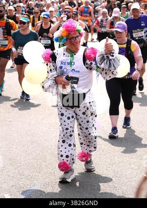 Die Läufer überqueren die Tower Bridge in schickem Kleid während des Mass Participation Race beim TCS London Marathon. Bilddatum: Sonntag, 27. April 2025. Stockfoto