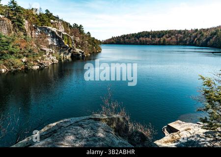 Kerhonkson, NY - USA - 23. April 2025 der Lake Awosting glitzert unter klarem Himmel, umgeben von zerklüfteten Klippen und bewaldeten Hügeln im Minnewaska State Park Stockfoto