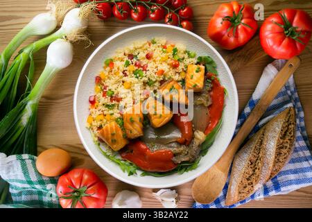 Gericht mit gebackenem Lachs, Paprika und Couscous-Salat. Tisch mit Blick von oben mit weihnachtsdekoration. Stockfoto