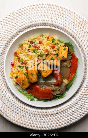 Gericht mit gebackenem Lachs, Paprika und Couscous-Salat. Tisch mit Blick von oben mit weihnachtsdekoration. Stockfoto